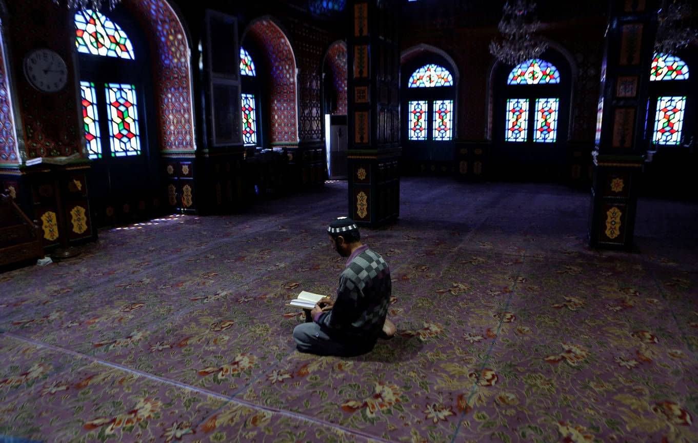 A caregiver reads the Quran inside a deserted shirne during the holy fasting month of Ramadan in Srinagar, Kashmir.