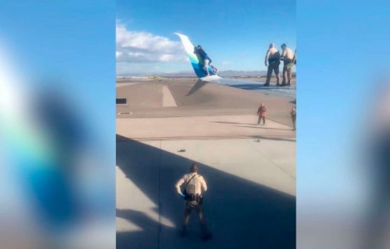 Man climbs onboard the wing of an airplane ready to take-off at Las Vegas airport